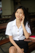 © tiniroma - Portrait of thai adult student university uniform beautiful girl calling smart phone