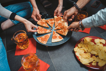 Wall Mural - Group of friends eating pizza - Millennials have fun together - Day of happiness between young men and women