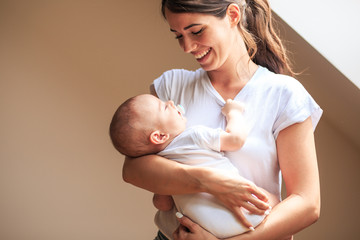 mother hugging and carrying her baby boy.tries to put baby to sleep.