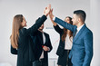 © GVS - Smiling young business people giving high five to each other in office