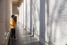 Man Looking At Fallen Soldier Names On Menin Gate Memorial Wall