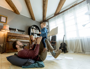 Wall Mural - Happy young family playing on the floor at rustic room