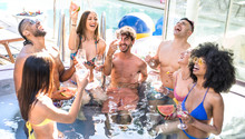 Side View Of Happy Friends Group Drinking White Wine Champagne At Swimming Pool Party - Luxury Vacation Concept With Young Guys And Girls Having Fun In Summer Day At Hotel Resort - Warm Bright Filter