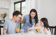 © Nattakorn - Asian family happy enjoy having breakfast on table in kitchen