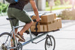 © pikselstock - Bicycle messenger making a delivery on a cargo bike