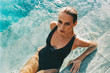 © visualspectrum/Stocksy - Beautiful Swimsuit Model Sitting in Shallow Pool Water Shot on Film