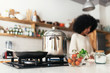 © Santi Nunez/Stocksy - Unrecognizable black woman cooking in the kitchen at home.