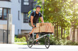 © pikselstock - Bicycle messenger making a delivery on a cargo bike