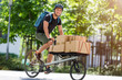 © pikselstock - Bicycle messenger making a delivery on a cargo bike