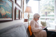 © Rob and Julia Campbell/Stocksy - Senior woman using tablet at home on couch
