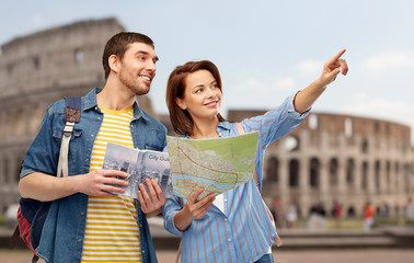 travel, tourism and vacation concept - happy couple of tourists with city guide, map and backpacks over coliseum background