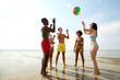 © Syda Productions - friendship, leisure and people concept - happy friends playing with inflatable ball on summer beach