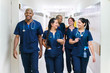 © Per Swantesson/Stocksy - Smiling team of doctors walking in hospital corridor