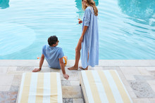 Couple Enjoying Wine Poolside At Luxury Resort