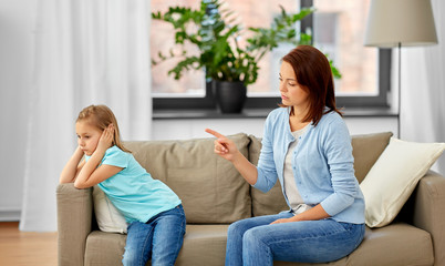 misbehavior, conflict and family concept - angry mother scolding her daughter at home