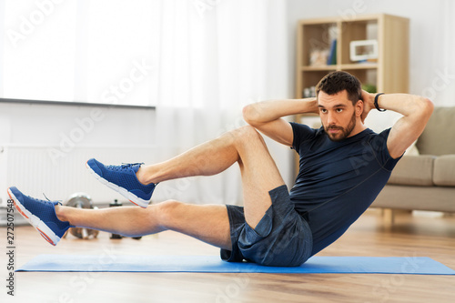 Cuadros en Lienzo sport, fitness and healthy lifestyle concept - man making bicycle crunch on exer