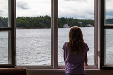 Girl Looking Out Of Boathouse Window