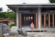 Woman In The Doorway Of Her First Home Under Construction
