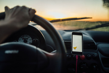 travel driving a car in the summer, the navigator in the smartphone. the driver is driving