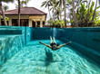 © Bisual Studio/Stocksy - Woman swimming on the pool of a private villa in Bali