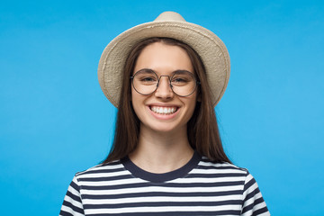 Wall Mural - Headshot of European Caucasian girl wearing summer hat and glasses and smiling happily