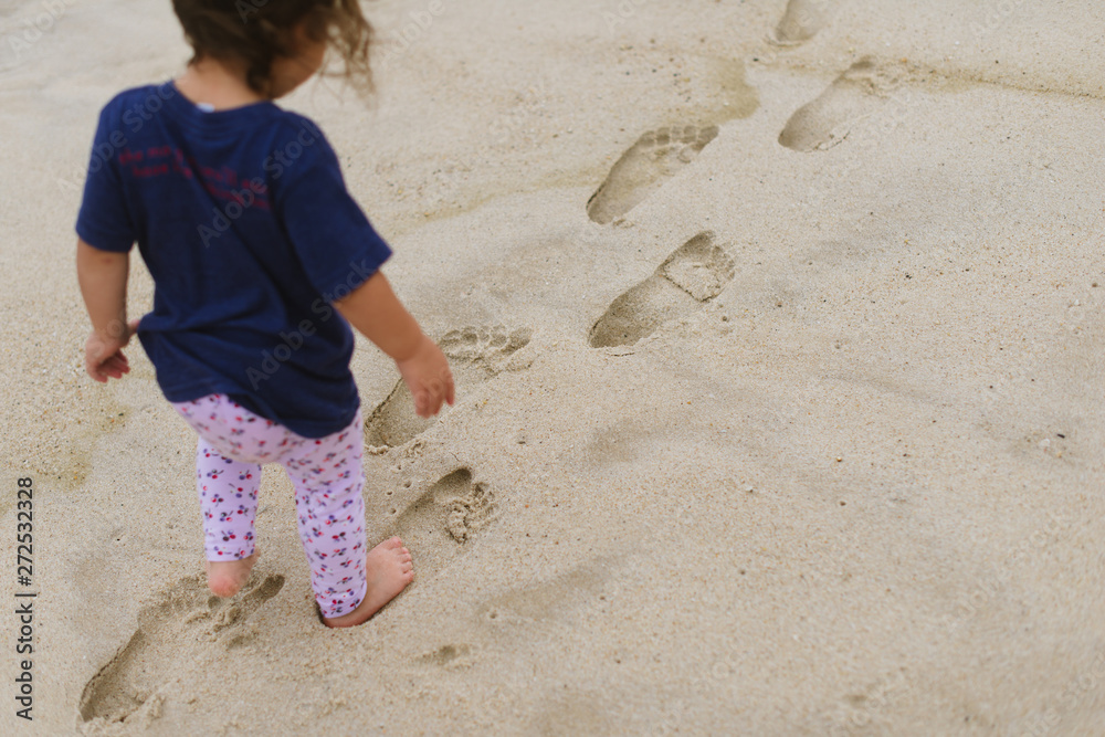 Little girl walking in footprints Stock Photo | Adobe Stock
