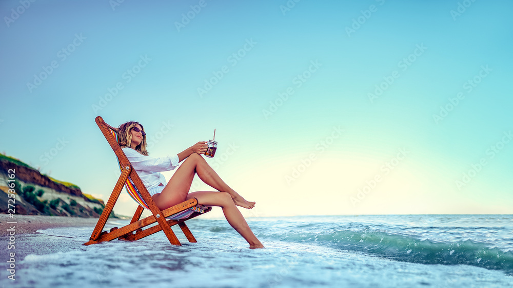 Pretty woman relaxing on a lounger beach and drinks soda water. summer vacation concept. - obrazy, fototapety, plakaty 