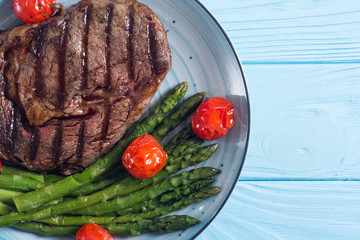 Wall Mural - Grilled beef steak ribeye with cherry tomatoes and asparagus