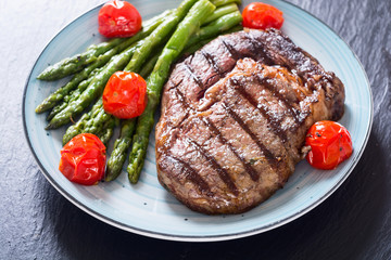 Wall Mural - Grilled beef steak ribeye with cherry tomatoes and asparagus