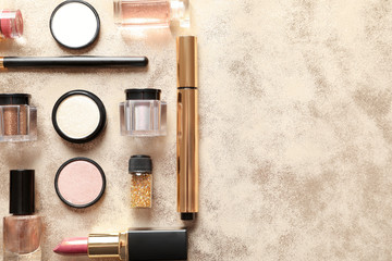 Different luxury makeup products on gold background, flat lay. Space for text