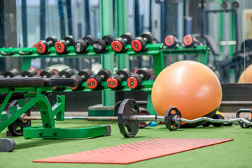 The background of the exercise equipment set for good health (steel balls, dumbbells, cable, weightlifting, boxing boxing gloves, fitness balls) has a blurred light that Fall 