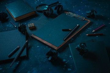 Science and research concept with a clipboard, black paper notes and a magnifying glass. Starry sky background. Dark business concept with copy space.