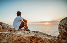 Lonely Guy Observing The Sunset From A Cliff In Cyprus