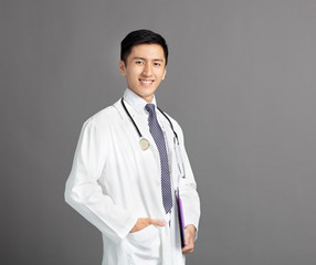 Wall Mural - young handsome man doctor isolated on gray background