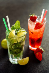 Red Green Mojito Strawberry Lemon Two Cocktail Set on Black Background. Cold Summer Fresh Mint Mohito with Juice and Ice. Berry Soda Beverage Decoration. Cuban Lemonade Water for Restaurant Bar