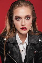 Sticker - Image of sexual fashion woman 20s with bright makeup wearing earrings and leather jacket posing at camera