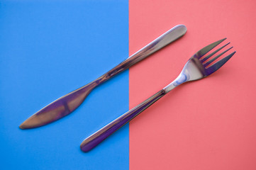 fork and knife on blue and pink background