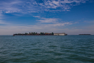 View of the islands, Venice, Italy. Lagoon on a bright summer day. Seascape with two islands, trees and houses on them.