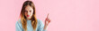 panoramic shot of sad teenage girl pointing with finger isolated on pink