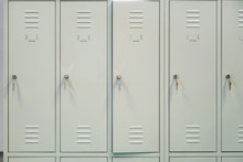 A Row Of Grey Metal School Lockers With Keys In The Doors