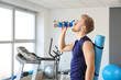© Pixel-Shot - Sporty young man drinking water in gym