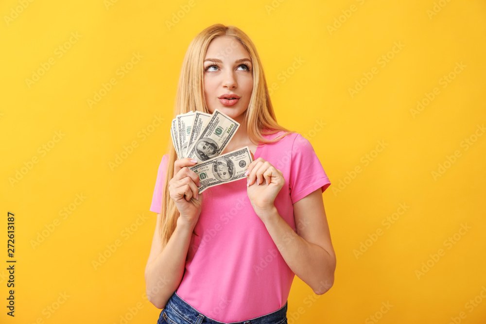 Thoughtful young woman with money on color background