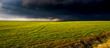 dark rainclouds over green field