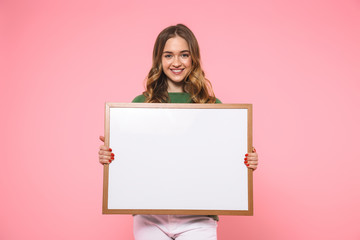 Wall Mural - Smiling blonde woman holding blank board and looking at camera