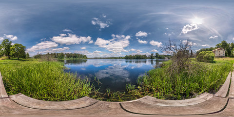 Wall Mural - full seamless spherical hdri panorama 360 degrees  angle view on wooden pier of huge lake or river in sunny summer day and windy weather with beautiful clouds in equirectangular projection, VR content