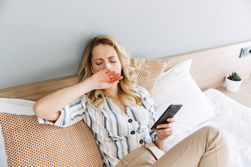 Poster - Beautiful young blonde woman relaxing in bed