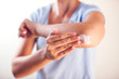 © Aleksej - Woman applies cream on dry elbow.People, healthcare and medicine concept