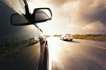 Black compact SUV car with storm clouds as background,transportation during bad weather condition concept.