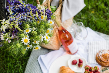 Wall Mural - Beautiful summer picnic with strawberries, cheese and rose wine on the lawn in the city park