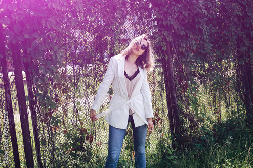 Stylish Hipster Girl Is Standing Near The Ivy Leaves Wall Outdoors